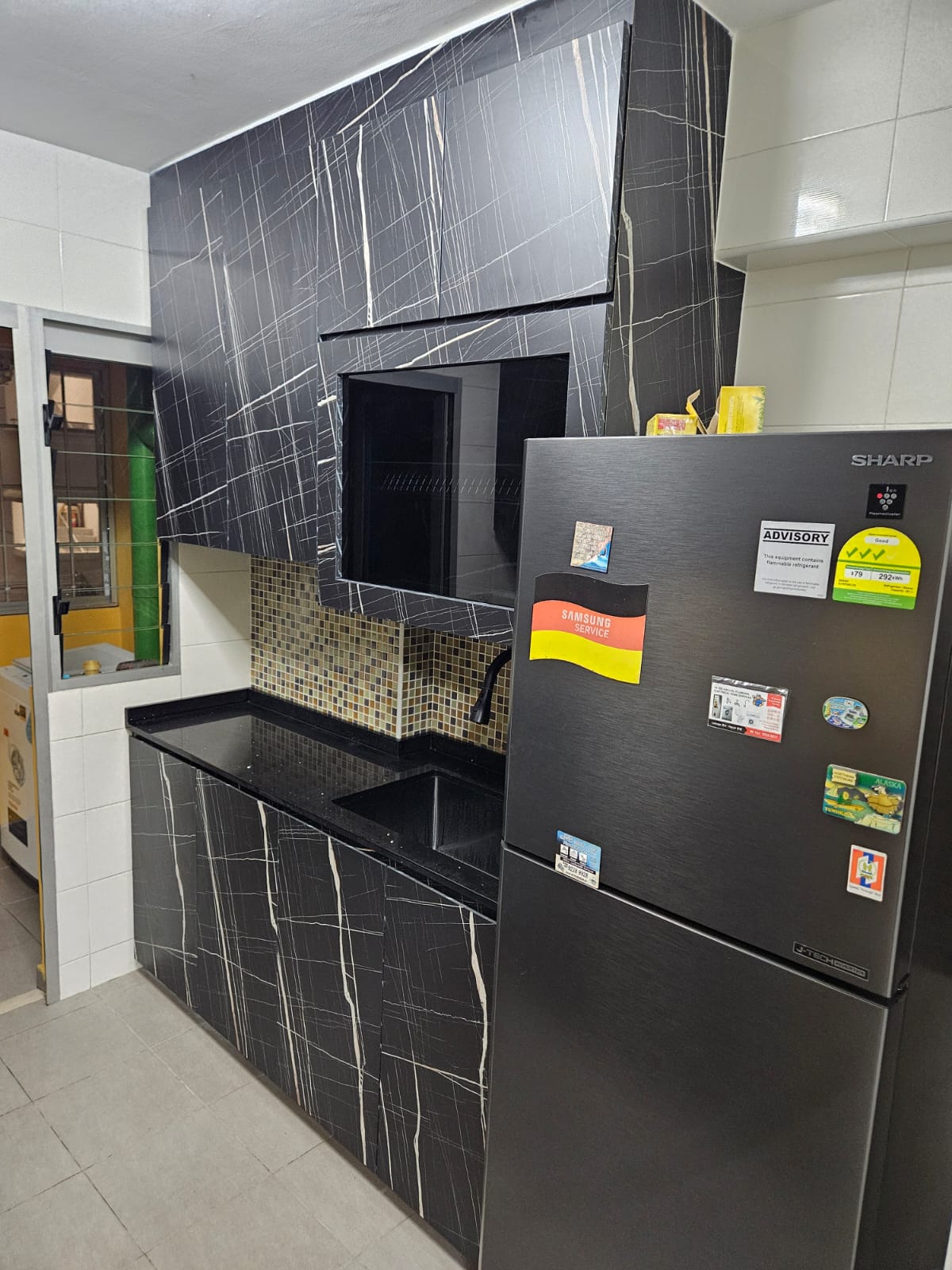 After: New dark marble-laminate kitchen cabinets with black granite countertop in HDB