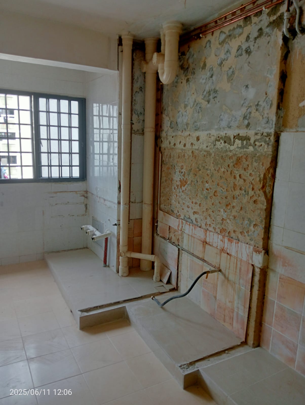 Before: Hacked HDB kitchen with old wall tiles removed, exposed pipes and plumbing