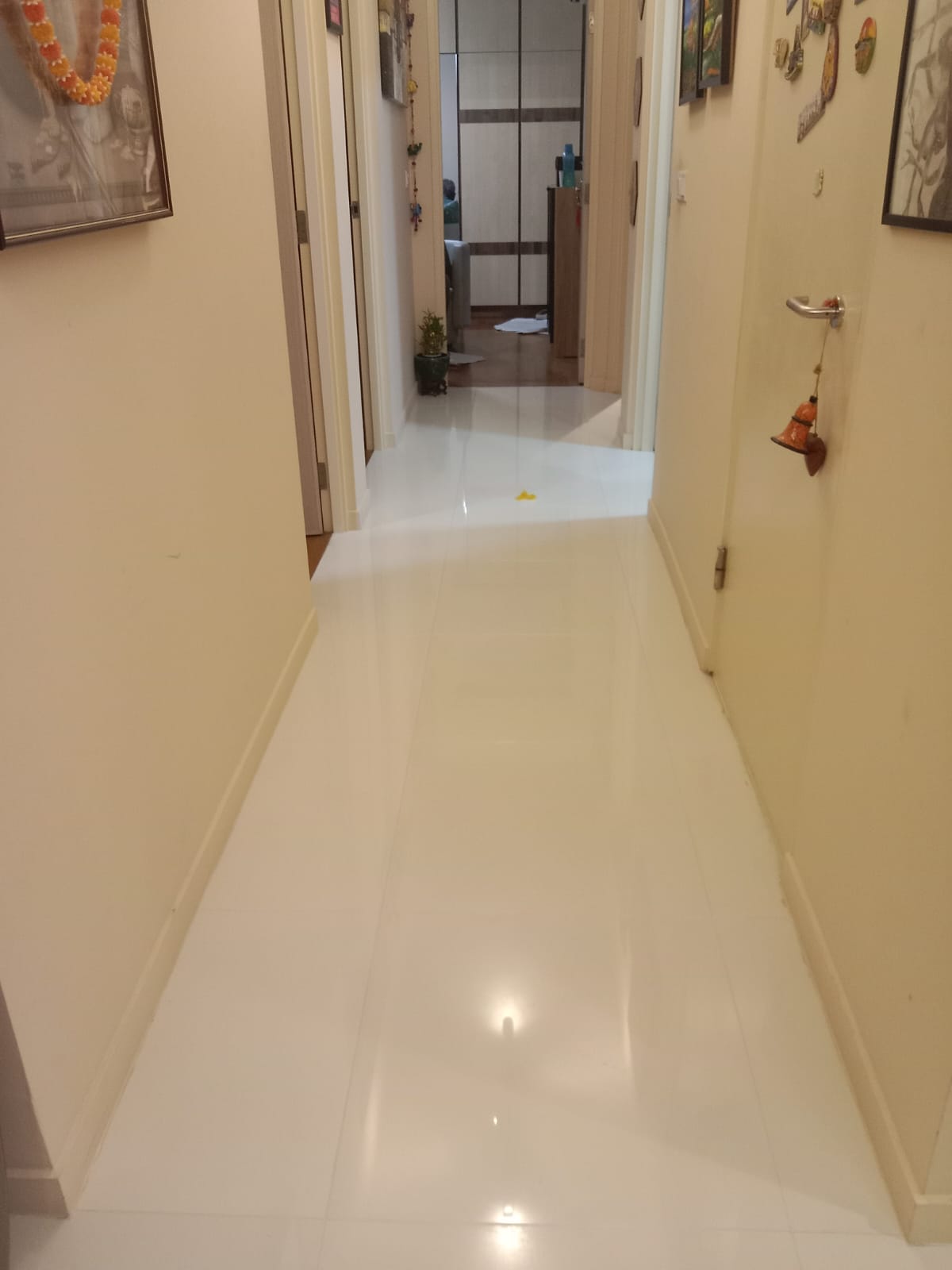After: Corridor and living area with freshly grouted white floor tiles