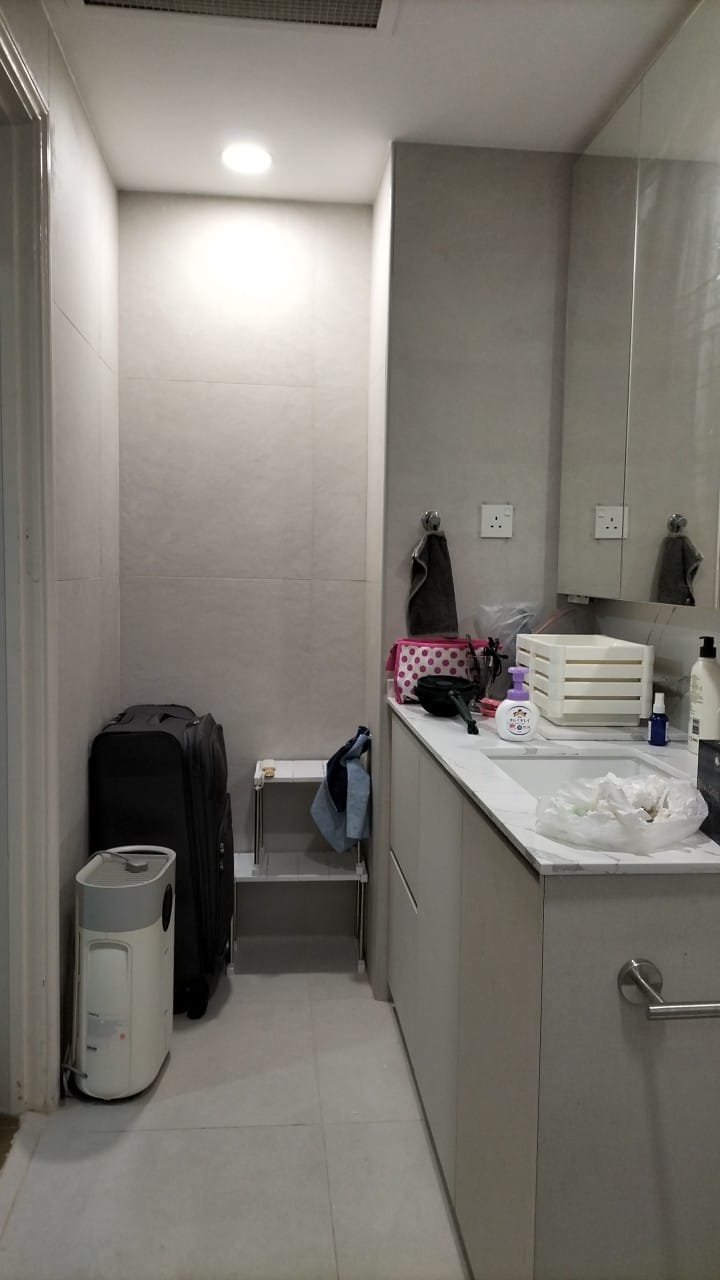 After: Completed modern condo bathroom with vanity, mirror, grey tiles, and downlight