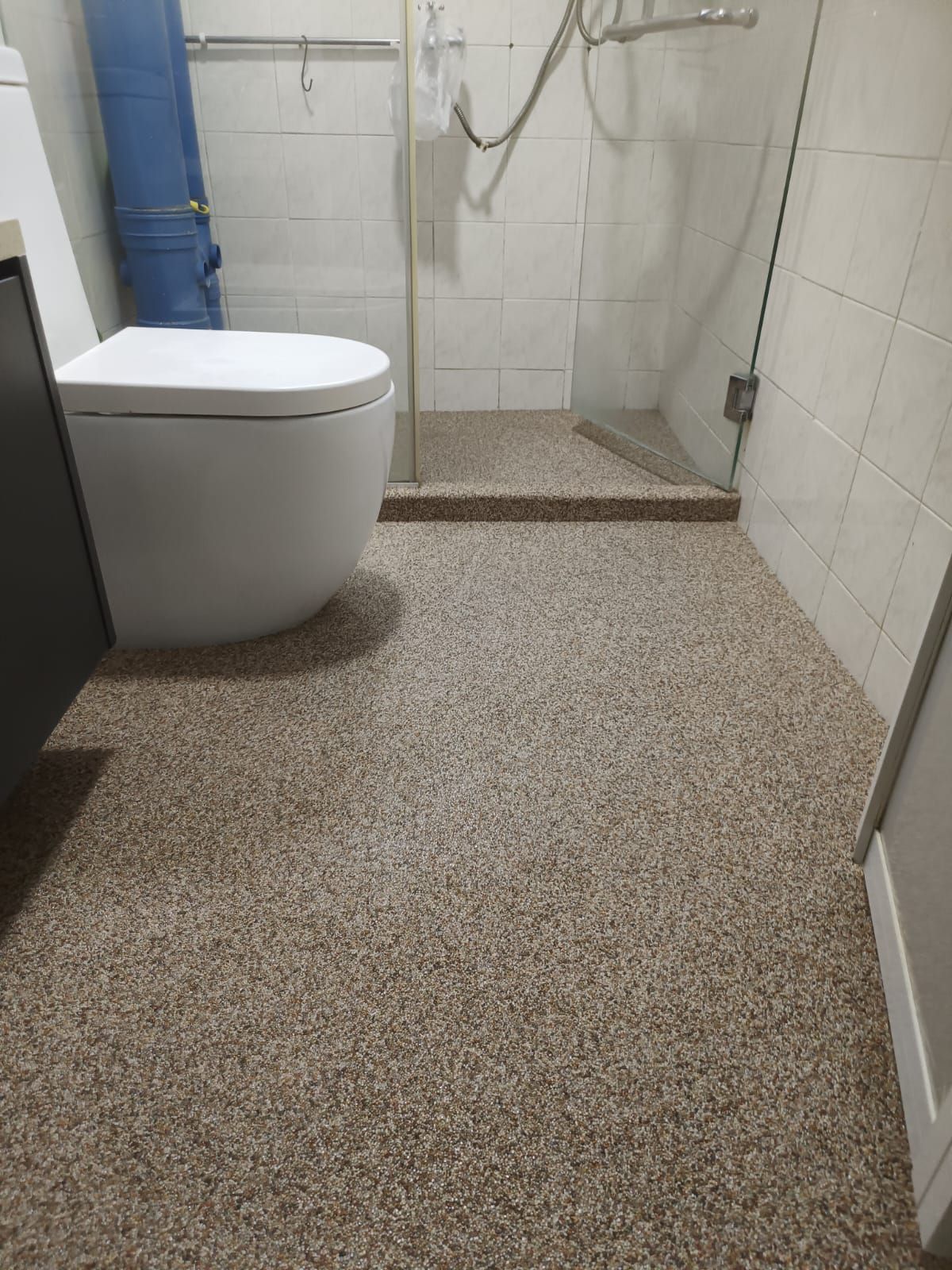 After: Pebble epoxy coating applied over bathroom floor in condo